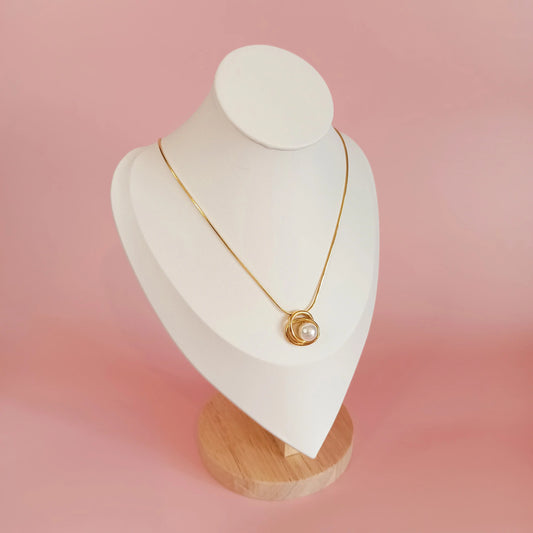 Collier en acier inoxydable Aurore avec une perle sur un présentoire
